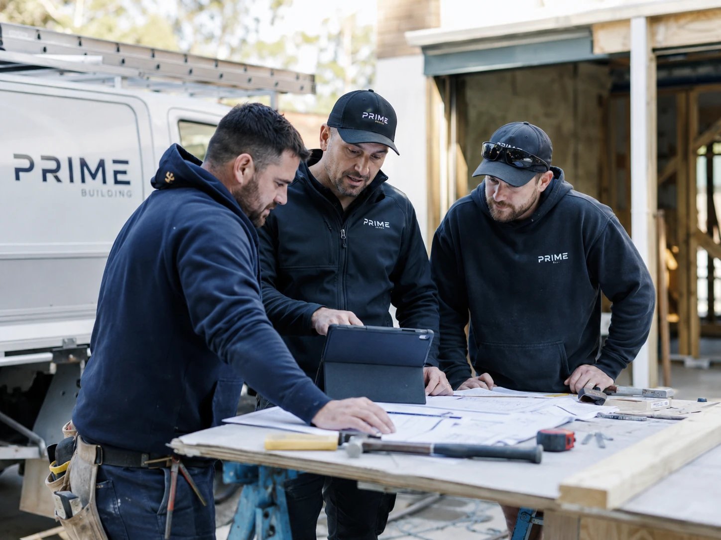 Australian trade business team reviewing project plans and job requirements on site